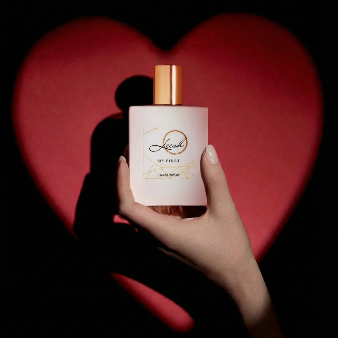Hand holding a Leesh perfume bottle with a red heart in the background. Her My First fragrance by Leesh Fragrances held by a girl in front of a red heart background for Valentine’s Day, featuring the scent notes of patchouli, cedarwood, vanilla, jasmine, rose, ylang-ylang, amber, and musk